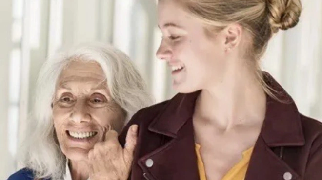 Eine ältere Frau hält sich am Arm einer jüngeren fest. Eine ältere Frau hält sich am Arm einer jüngeren fest.