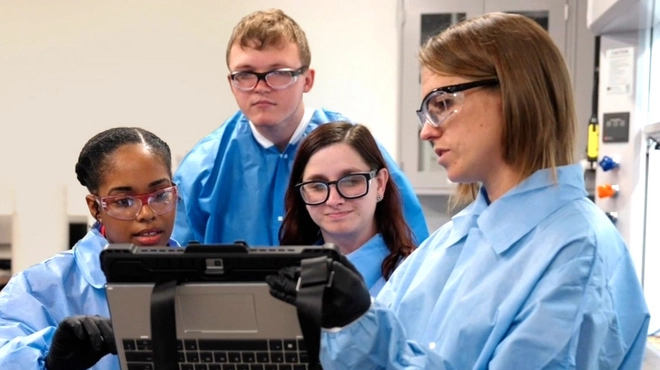 Scientists in a laboratory looking at a tablet Scientists in a laboratory looking at a tablet