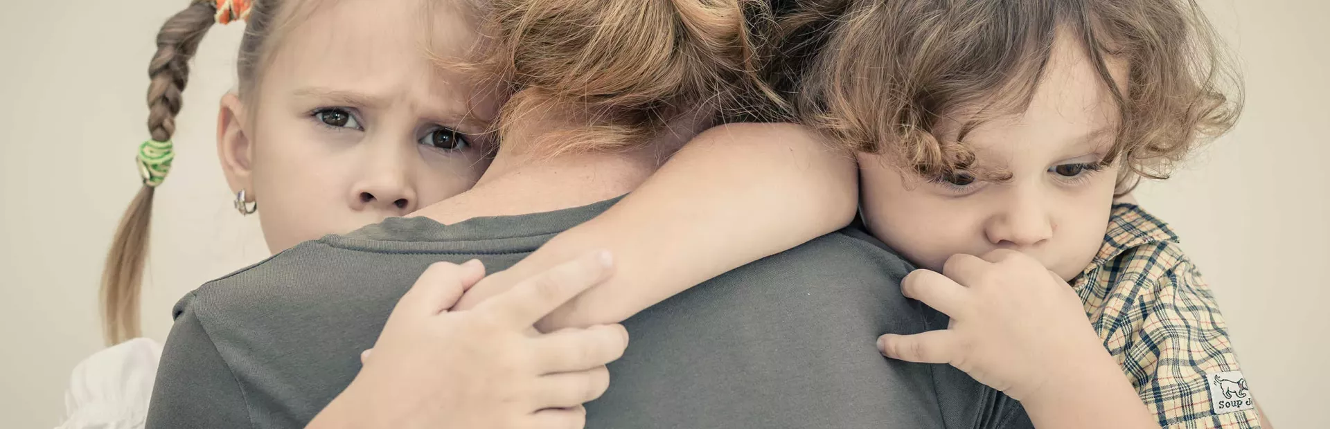 Mujer abrazando a sus hijos