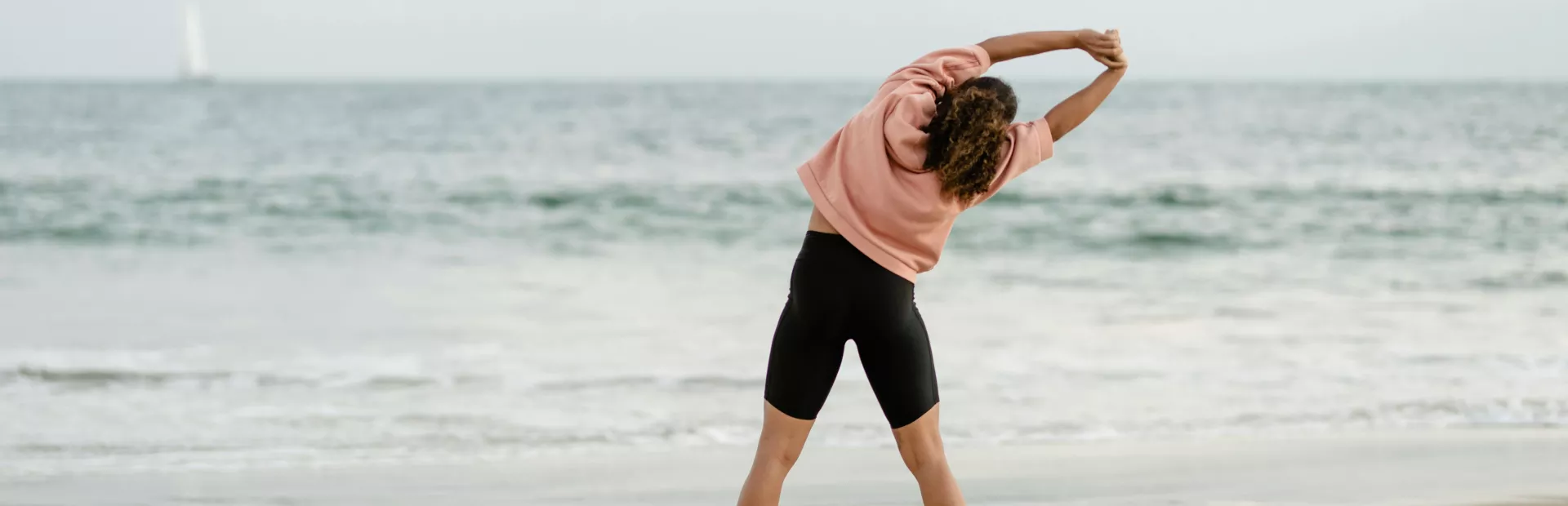 Mujer estirando en la playa