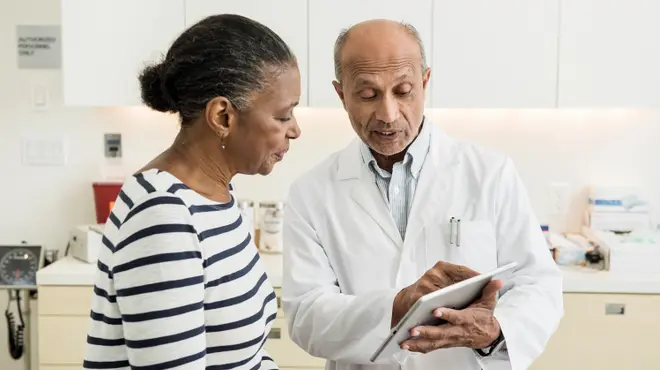 Lääkäri näyttää potilaalle tablettia Lääkäri näyttää potilaalle tablettia