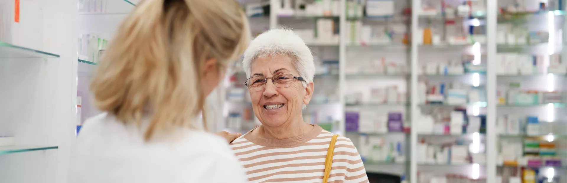 Oudere vrouw in gesprek met apotheker