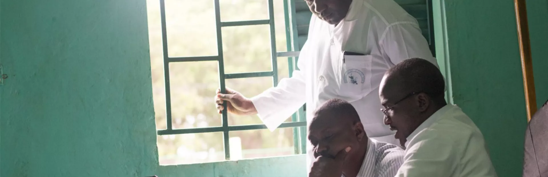 Dr. Bakary Fofana and colleagues look at a computer screen