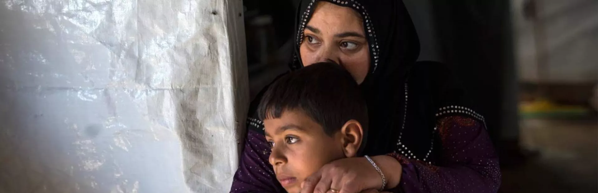 Syrian refugees ponder an uncertain future: Zakiya, one of the daughters of Hamid, with her son Waleed, age 10, in their makeshift home.