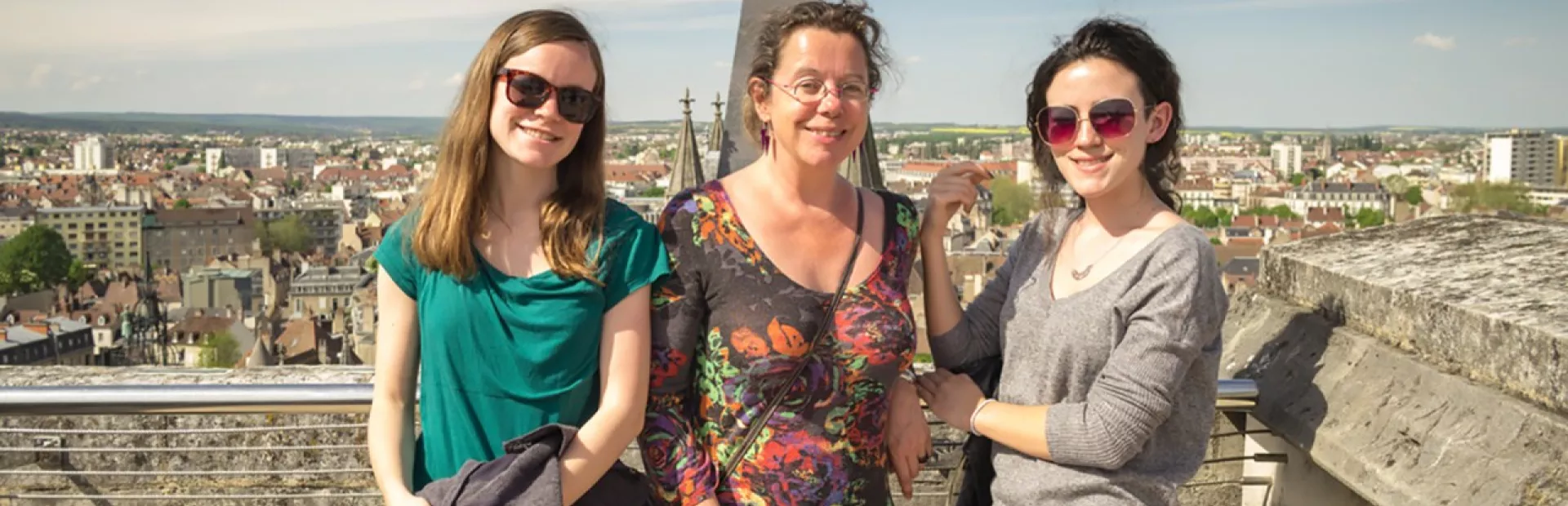 Lauren Abrey and her two daughters posing in front of a city.