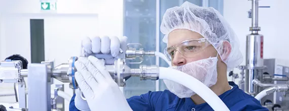 Novartis production specialist connects tubes in a manufacturing plant 