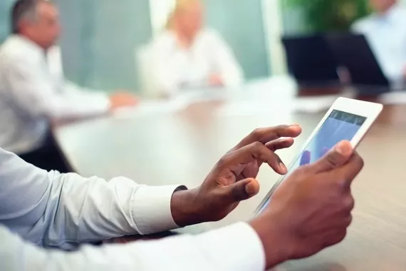 A business person using a tablet during a meeting