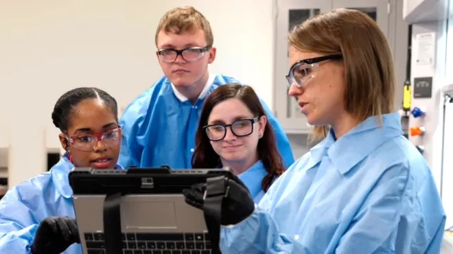 Scientists in a laboratory looking at a tablet