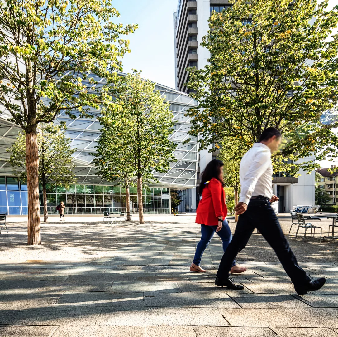 Two persons walking around the Basel campus