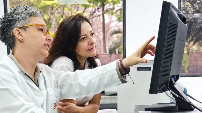 Doctors viewing computer screen to comprehend data Doctors viewing computer screen to comprehend data
