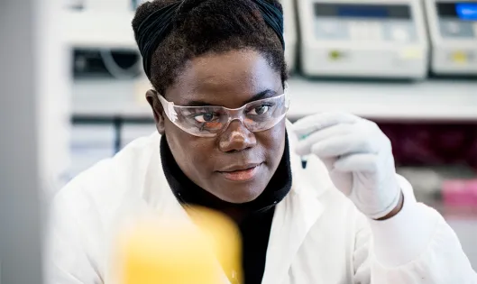 A female research scientist in a lab looking at a sample A female research scientist in a lab looking at a sample
